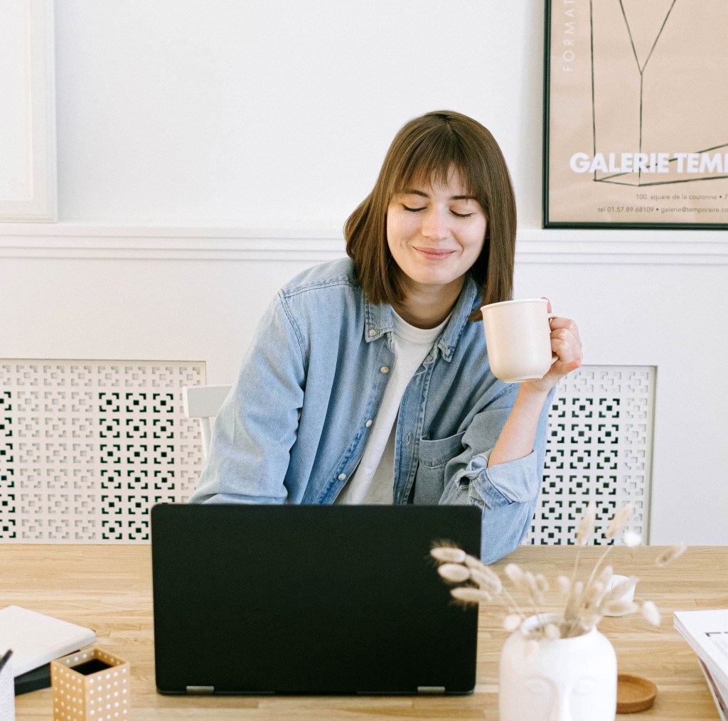 Woman working on a laptop with coffee